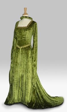 Cordelia, a  Celtic Inspired Medieval, Pre- Raphaelite,Renaissance Gown, Handfasting Gown with Celtic Embroidery. Pictured here in olive green crushed velvet with old gold embroidery. Many colour choices available.   For full range of colours go to www.frockfollies.com FREE INSURED AND TRACKABLE SHIPPING PERFECT FOR SO MANY OCCASIONS: GOTHIC EVENTS MEDIEVAL/RENAISSANCE/ELVISH WEDDINGS LARP EVENTS RE ENACTMENTS HANDFASTING CEREMONIES LARP EVENTS YOUR INNER GODDESS MOMENTS! HAND MADE IN ENGLAND BY AN EXPERIENCED THEATRICAL COSTUMIER THIS OUTFIT IS AVAILABLE TO ORDER IN A WIDE RANGE OF COLORS AND CUSTOM MADE TO YOUR OWN MEASUREMENTS. frockfollies PRIDES ITSELF ON QUALITY OF WORKMANSHIP AND ATTENTION TO DETAIL. THIS ELEGANT FLOWING DRESS IS  MADE IN A LUXURIOUS SOFT DRAPEY  OLIVE GREEN CRUSHED Floor-length Medieval Dress For Costume, Green Historical Costume Dress, Medieval Gown With Historical Design For Costume Party, Medieval Floor-length Dress With Historical Design, Floor-length Medieval Dress With Historical Design, Medieval Style Floor-length Dress With Historical Design, Medieval Costume Gown With Historical Design, Green Fitted Medieval Dress, Fitted Medieval Floor-length Gown