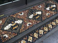 a close up of a decorative door mat on the side of a building with rocks and stones