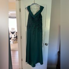 a green dress hanging on a door way