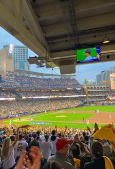 a baseball stadium filled with people watching a game