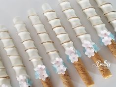 there are many white and blue flowers on the cake sticks that look like they were made out of marshmallows