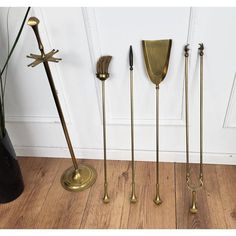 five brass - plated candlesticks are lined up on the floor in front of a white door