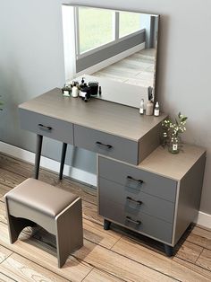 a dressing table and stool with a large mirror on the wall