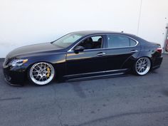 a black car parked in front of a white wall