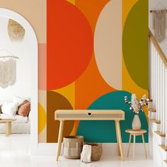 a living room with colorful wallpaper and white stairs leading up to the second floor