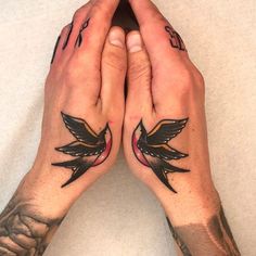 two hands with tattoos on them holding each other's palms and touching their fingers