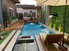 an outdoor swimming pool surrounded by greenery and patio furniture with umbrellas over it