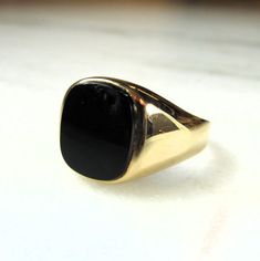 This is a vintage 14K yellow gold mens black onyx stone ring.  The onyx is 14mm long x 11.5mm wide.  The band is sized at 13 1/2.  The inside of the band is not marked.  We have tested the gold for karat.  It is 14K.  Total weight of the ring is 5.4 grams. This is a vintage, previously owned ring.  Therefore, light wear can be expected.  There is no visible damage. Classic Onyx Signet Ring With Polished Finish, Timeless Onyx Signet Ring With Polished Finish, Minimalist Onyx Signet Ring For Formal Events, Minimalist Onyx Signet Ring For Formal Occasions, Classic Onyx Signet Ring With Black Enamel, Timeless Black Enamel Signet Ring For Formal Occasions, Classic Black Signet Ring With Polished Edges, Black Luxury Signet Ring For Formal Events, Luxury Black Signet Ring For Formal Occasions