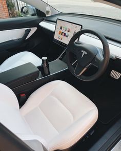 the interior of an electric vehicle with a laptop on the dashboard and other electronic gadgets