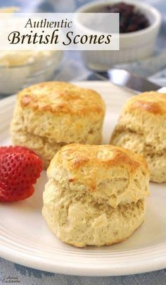 three biscuits on a white plate with strawberries