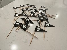 a bunch of black and white flags with skulls on them sitting on a counter top