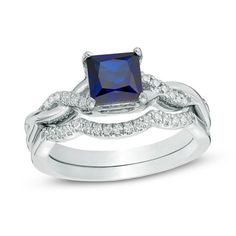 an engagement ring set with a blue sapphire and diamond accents on the band, in white gold