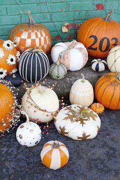 pumpkins with numbers on them sitting in front of a brick wall