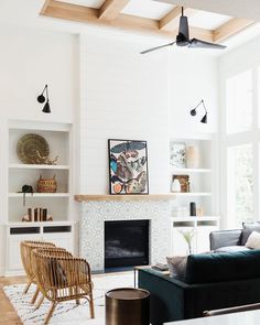 a living room filled with furniture and a fire place in front of a white wall