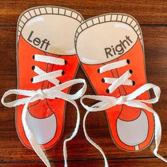 an orange pair of shoes with white laces tied to them on top of a wooden floor