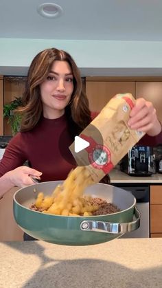 a woman is pouring some food into a pan