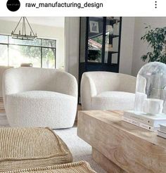 two white chairs sitting next to each other on top of a wooden table in a living room