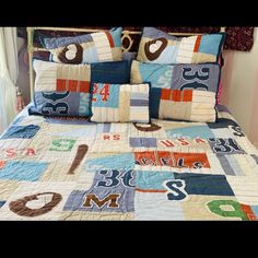 a bed with blue and orange quilts on it