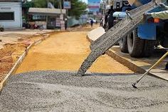 a man is pouring cement on the street