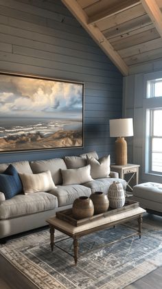 a living room filled with furniture and a large painting hanging on the wall above it