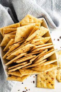 some crackers are in a white dish on a towel