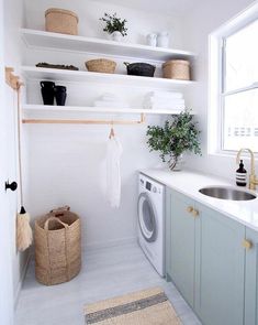 a washer and dryer in a small room with shelves above the washer