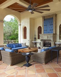 a living room with couches, tables and a ceiling fan in front of a fireplace