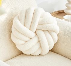 a white ball of yarn sitting on top of a chair