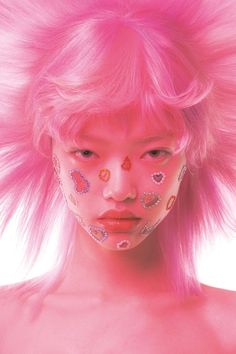 a woman with pink hair and makeup has hearts on her face as if it were from the 80's