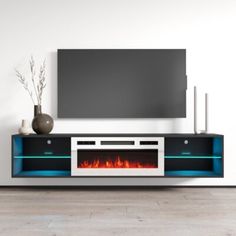 a television stand with a fire place in the center and a flat screen tv above it