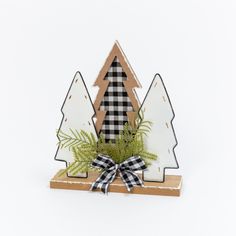 This tasteful 12-in high trio of winter trees will be a welcome accent to any holiday décor. Made of wood, there are two white painted trees framing a wood tree with black and white buffalo plaid inlay. Standing on a natural wood base, winter greenery and a plaid bow ad a note of added interest Gerson International 12-in Christmas Tree(s) Christmas Decor | 2594900EC Painted Trees, Farmhouse Decorations, Buffalo Plaid Christmas Tree, Winter Greenery, Holiday Trees, Plaid Christmas Tree, Tabletop Christmas Tree, Wood Christmas Tree, Buffalo Plaid Christmas