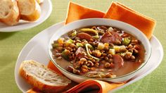 a white bowl filled with soup next to two slices of bread on top of a green table cloth