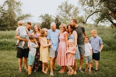 a group of people that are standing in the grass with some kids and an adult