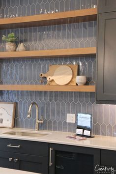 a kitchen counter with wooden shelves above it