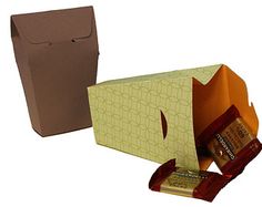 an open box and some chocolates on a white background with a brown paper bag