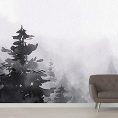 a chair sitting in front of a wall with trees painted on it