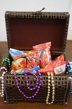 a trunk filled with candy and candies sitting on top of a wooden table in front of a wall