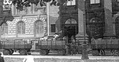 an old black and white photo of people walking in front of a large brick building