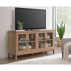 This sleek, versatile Bellamy console is the perfect stylish storage solution for any area of your home. Crafted of birch veneers on hardwood solids, this console can be used as a storage/serving piece in a dining room, to create organization in an entryway, to house a library, or to become a media/entertainment center. The top surface Is spacious enough for a beautiful floral arrangement, family photos, a decorative lamp or a set of elegant candle holders. Adjustable shelves allow you to c Transitional Family Room The Home Depot, Media Consoles With Glass Doors, Kelly Clarkson Tv Stand, Garage Bonus Room, Living Room Storage Ideas, Upscale Decor, Creative Shelving, Media Entertainment Center, Elegant Candle Holders