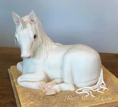 a white horse statue sitting on top of a wooden table