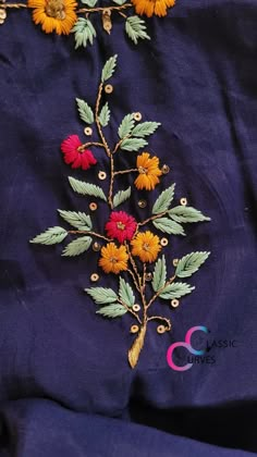 an embroidered blue cloth with yellow and red flowers on it