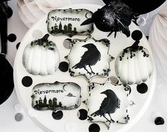 a white plate topped with black and white decorated cookies