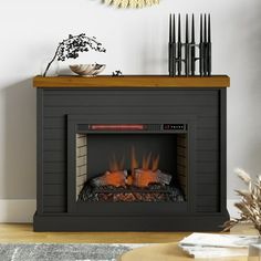 a fire place in a living room with a clock on the wall and candles around it