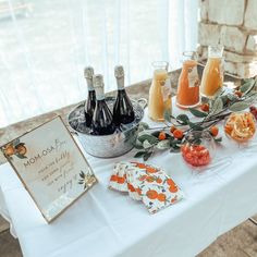 a table topped with bottles of wine and oranges next to a sign that says mom's day