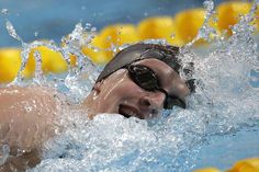 a man swimming in a pool with goggles on