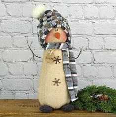 a snowman figurine with a hat and scarf on top of a wooden table