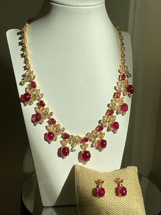 Ruby Necklace and Matching Earrings Set Necklace: 18 pcs. of Ruby from Africa, with 178 pcs. multi-shaped White Zircon, and tiny pieces of Pink Topaz on 92.5 Silver with golden niello ware setting.  Color/ Shape of Ruby: Purplish Red/ Oval Dimension: 18.5" long, 2" extender chain Dimension of the middle dangling part: 1.5" long Total Weight : 86.79 g. (with setting) Earrings: 1 pc. of Ruby and 2 pcs. of White Zircon on each with tiny pieces of Pink Topaz on 92.5 Silver with golden niello ware se Luxury Jewelry Sets With Round Jewels, Luxury Round Jewels Jewelry Sets, Luxury Jewelry Sets With Sparkling Stones, Luxury Ruby Jewelry With Stones, Luxury Hand Set Ruby Jewelry Sets, Formal Ruby Jewelry With Stones, Fine Ruby Jewelry With Stones, Luxury Ruby Jewelry Sets As Gift, Formal Gold-plated Jewelry With Stones