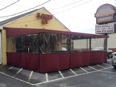 the outside of a restaurant that is covered in red tarp and yellow awnings