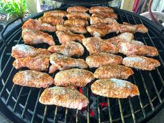 several pieces of meat cooking on an outdoor grill