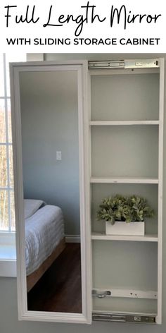 the full length mirror with sliding storage cabinet is in front of a bed and window